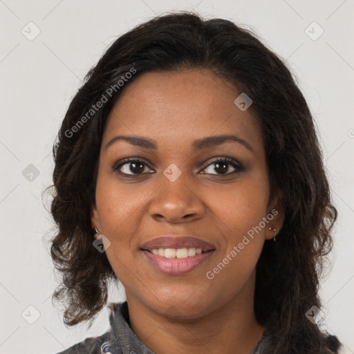 Joyful black young-adult female with long  brown hair and brown eyes