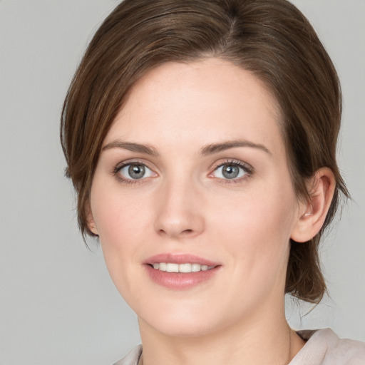 Joyful white young-adult female with medium  brown hair and green eyes