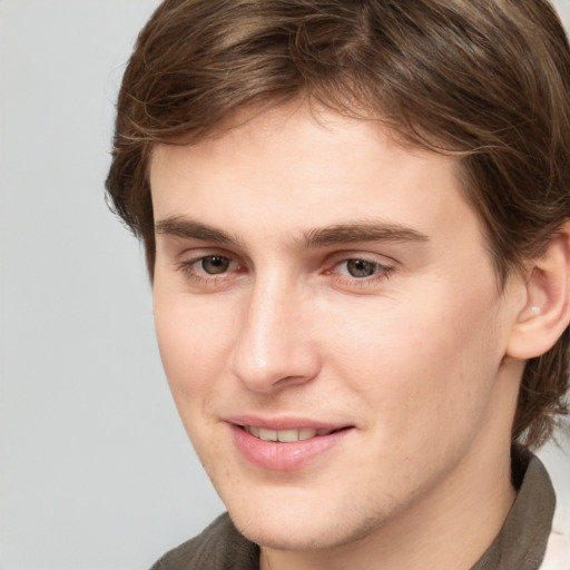 Joyful white young-adult male with medium  brown hair and grey eyes