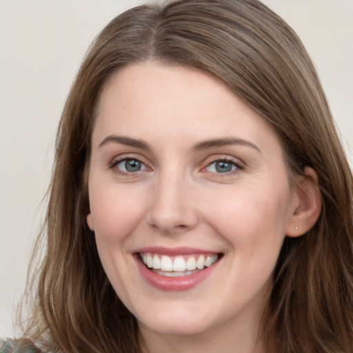 Joyful white young-adult female with long  brown hair and grey eyes