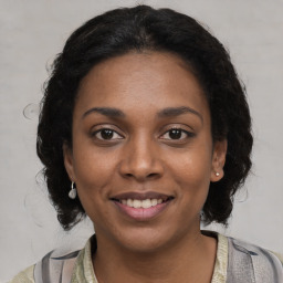 Joyful black young-adult female with medium  brown hair and brown eyes