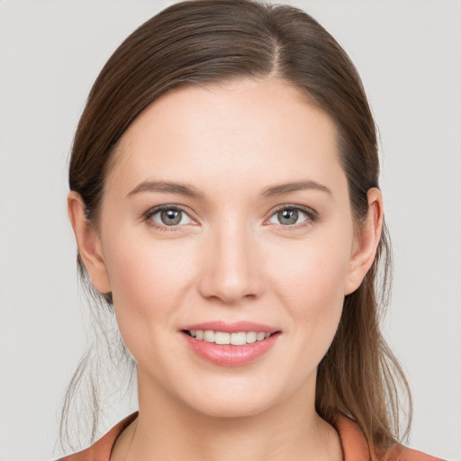 Joyful white young-adult female with medium  brown hair and grey eyes