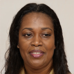 Joyful black adult female with long  brown hair and brown eyes