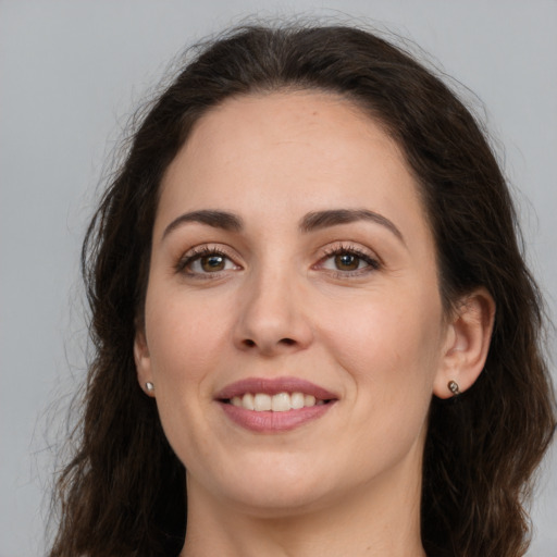 Joyful white young-adult female with long  brown hair and brown eyes