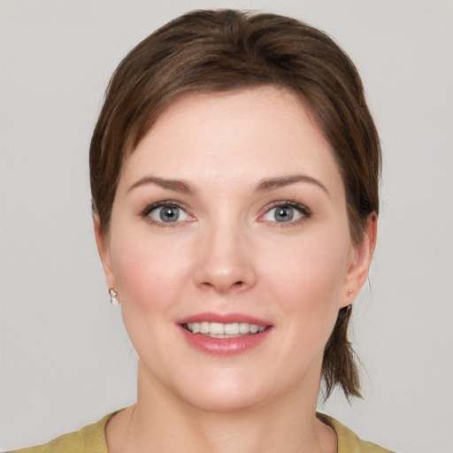 Joyful white young-adult female with medium  brown hair and grey eyes