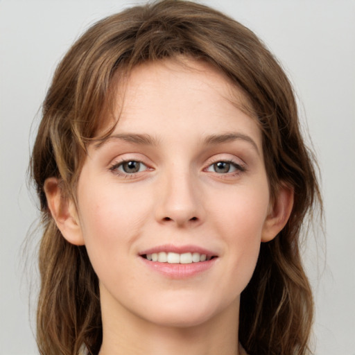 Joyful white young-adult female with long  brown hair and green eyes