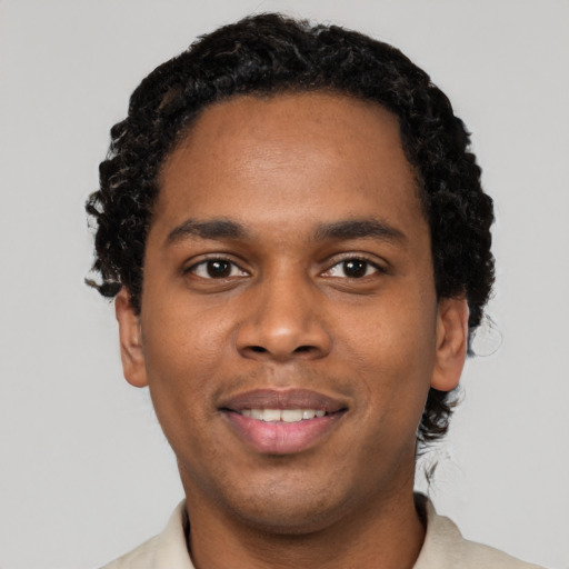 Joyful black young-adult male with short  black hair and brown eyes