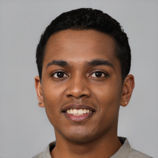 Joyful black young-adult male with short  black hair and brown eyes