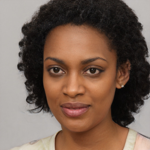 Joyful black young-adult female with medium  black hair and brown eyes