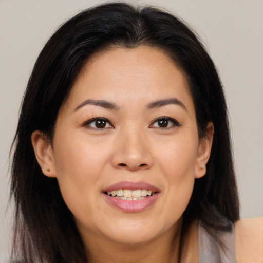 Joyful asian young-adult female with long  brown hair and brown eyes
