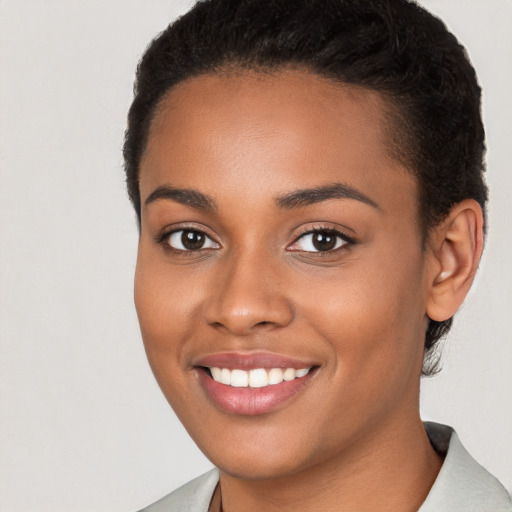 Joyful black young-adult female with short  brown hair and brown eyes