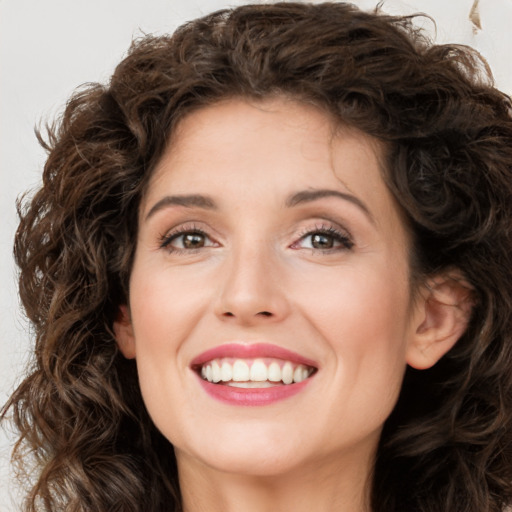 Joyful white young-adult female with long  brown hair and green eyes