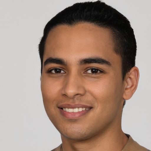 Joyful latino young-adult male with short  black hair and brown eyes