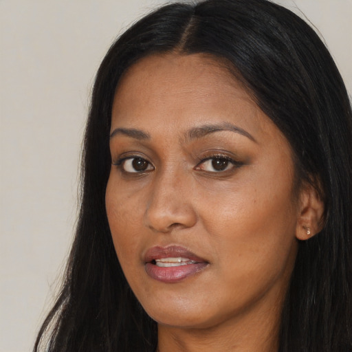 Joyful black adult female with long  brown hair and brown eyes