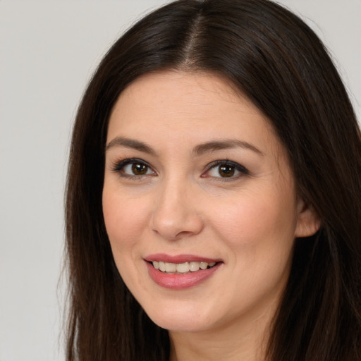 Joyful white young-adult female with long  brown hair and brown eyes