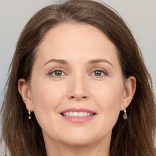 Joyful white young-adult female with long  brown hair and grey eyes