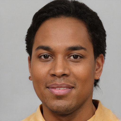 Joyful black young-adult male with short  brown hair and brown eyes