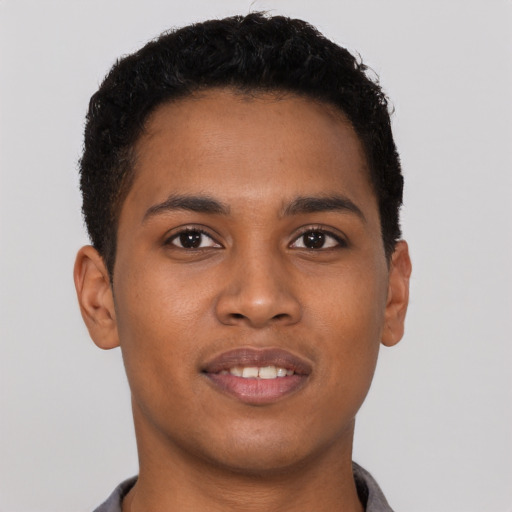 Joyful black young-adult male with short  brown hair and brown eyes