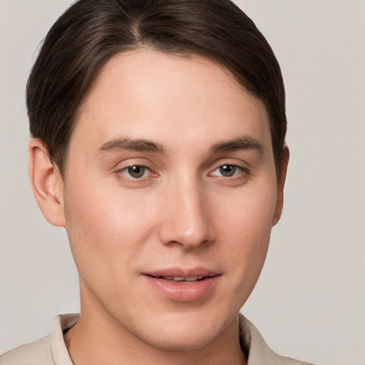 Joyful white young-adult male with short  brown hair and grey eyes