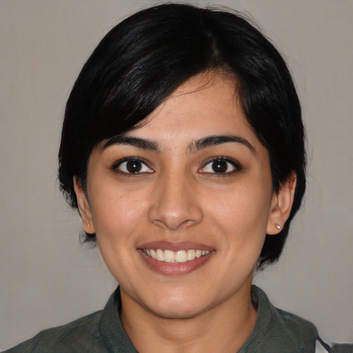 Joyful white young-adult female with medium  black hair and brown eyes