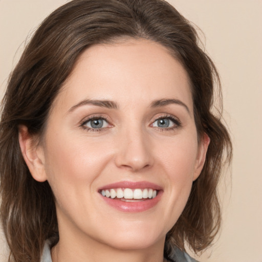 Joyful white young-adult female with medium  brown hair and green eyes