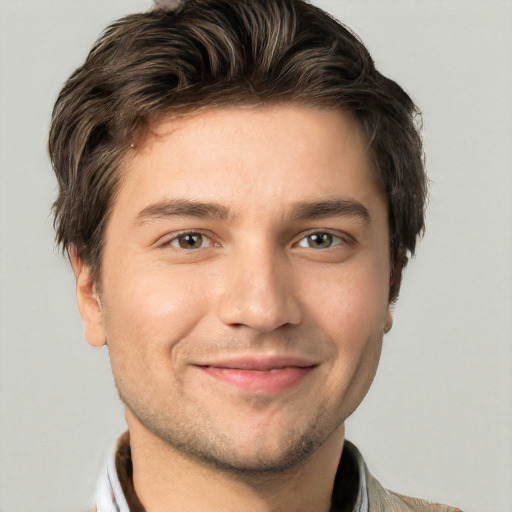 Joyful white young-adult male with short  brown hair and grey eyes