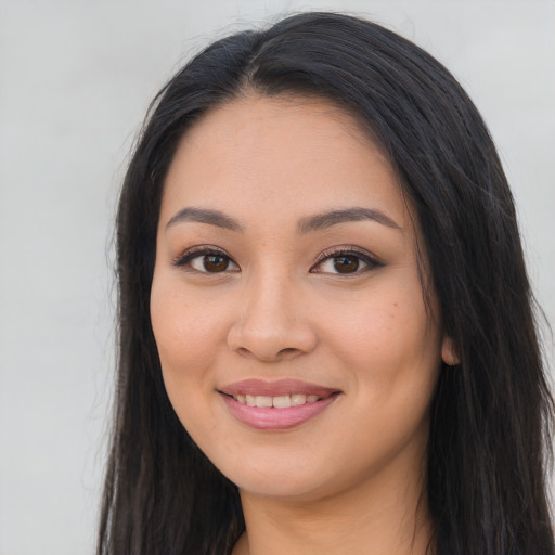 Joyful latino young-adult female with long  black hair and brown eyes