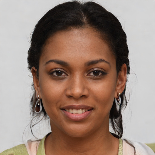 Joyful black young-adult female with short  brown hair and brown eyes