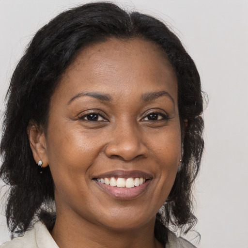 Joyful black adult female with medium  brown hair and brown eyes