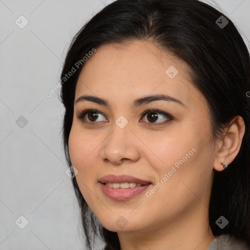 Joyful latino young-adult female with long  brown hair and brown eyes