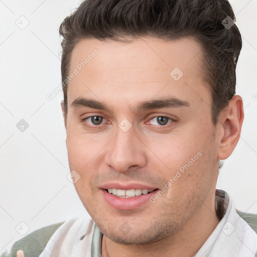 Joyful white young-adult male with short  brown hair and brown eyes