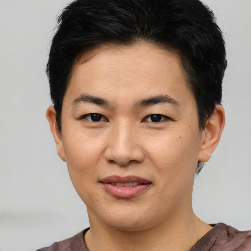 Joyful asian young-adult female with short  brown hair and brown eyes