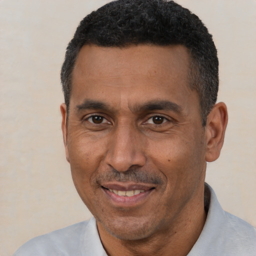 Joyful latino adult male with short  black hair and brown eyes