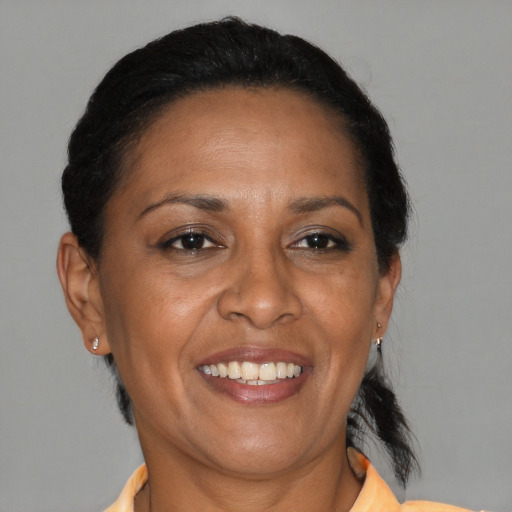 Joyful black adult female with medium  brown hair and brown eyes