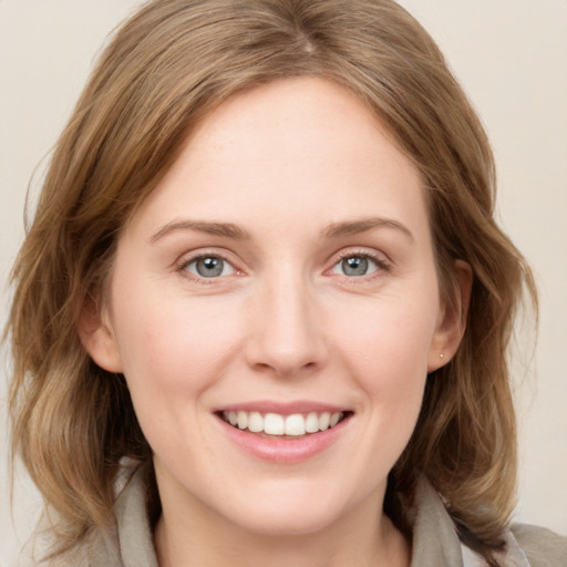 Joyful white young-adult female with medium  brown hair and grey eyes