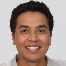 Joyful latino adult male with short  black hair and brown eyes