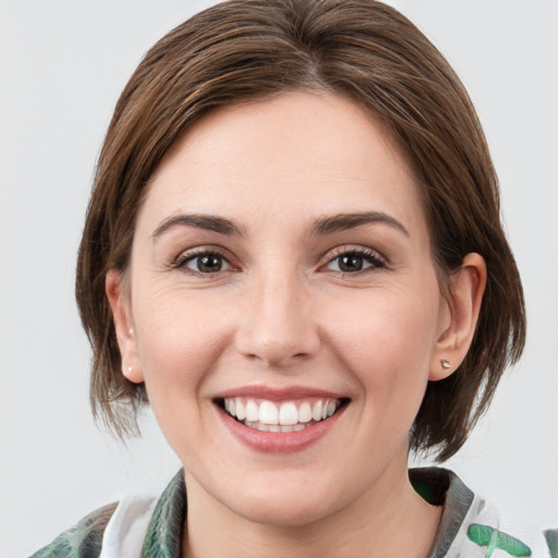 Joyful white young-adult female with medium  brown hair and green eyes