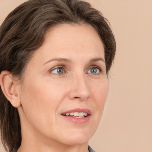 Joyful white adult female with medium  brown hair and blue eyes