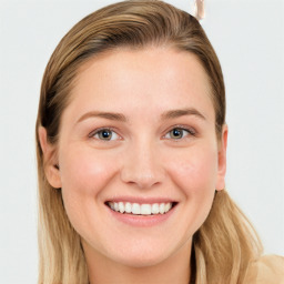 Joyful white young-adult female with long  brown hair and blue eyes