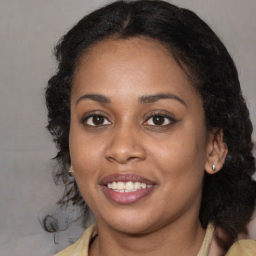 Joyful black young-adult female with medium  brown hair and brown eyes
