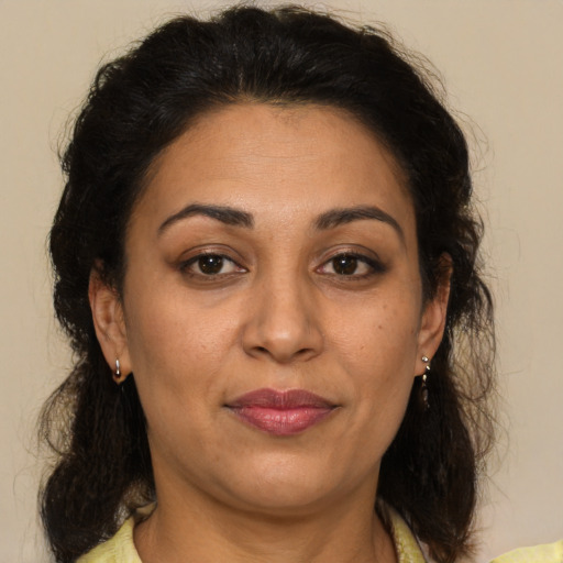 Joyful latino adult female with medium  brown hair and brown eyes