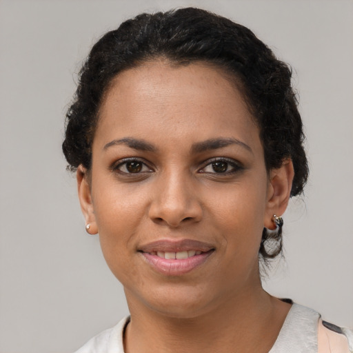 Joyful black young-adult female with short  brown hair and brown eyes