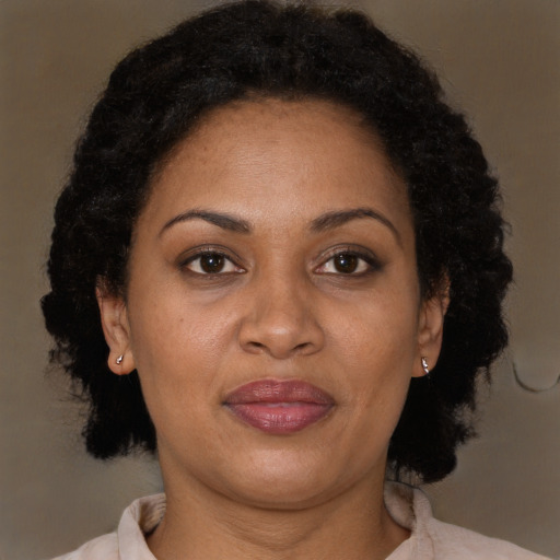 Joyful latino adult female with medium  brown hair and brown eyes