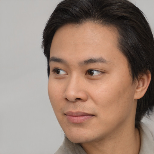 Joyful asian young-adult male with short  black hair and brown eyes