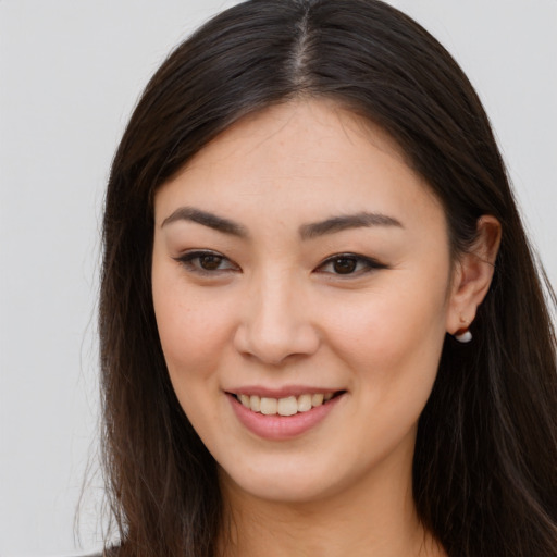 Joyful asian young-adult female with long  brown hair and brown eyes