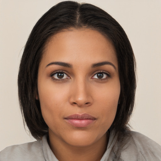 Joyful latino young-adult female with long  brown hair and brown eyes