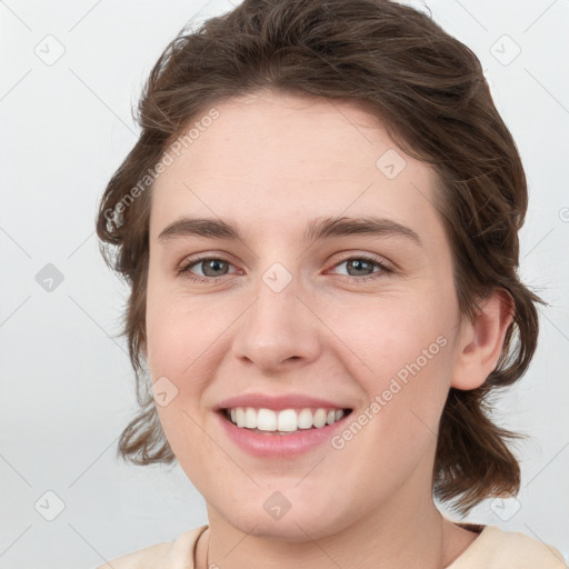 Joyful white young-adult female with medium  brown hair and grey eyes