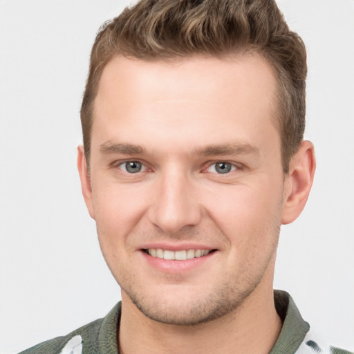 Joyful white young-adult male with short  brown hair and grey eyes