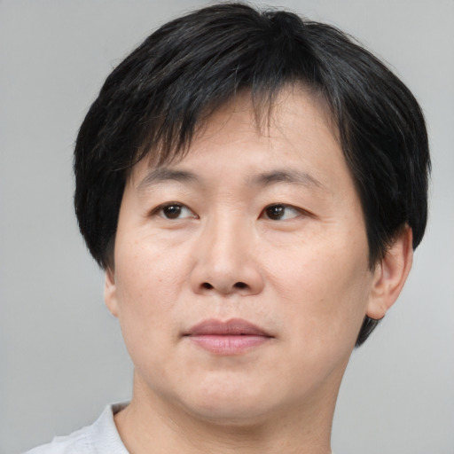 Joyful asian adult male with short  brown hair and brown eyes
