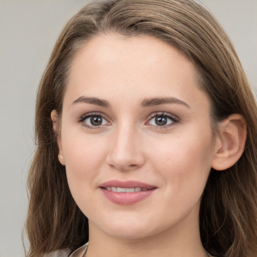 Joyful white young-adult female with long  brown hair and grey eyes